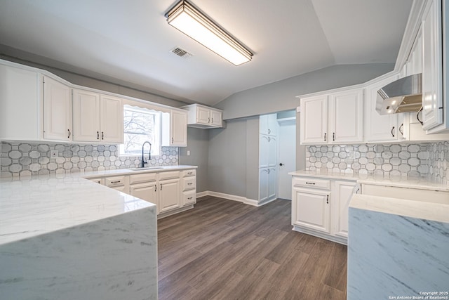 kitchen featuring lofted ceiling, sink, wall chimney range hood, white cabinets, and dark hardwood / wood-style flooring