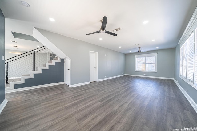 unfurnished living room with dark hardwood / wood-style flooring and ceiling fan