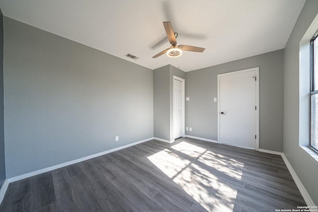 spare room featuring dark wood-type flooring and ceiling fan