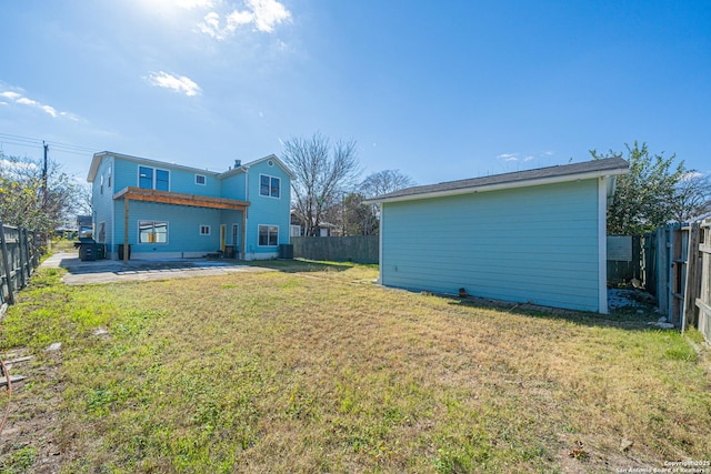 back of house featuring a lawn and a patio