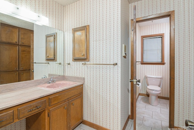 bathroom with tile patterned flooring, vanity, and toilet