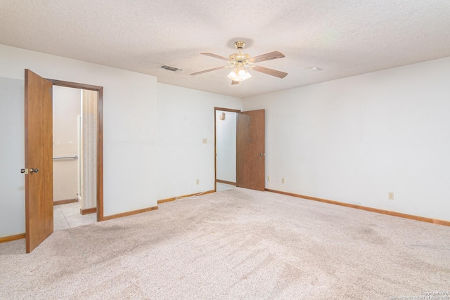 carpeted empty room featuring ceiling fan and a textured ceiling