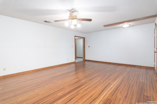 unfurnished room featuring hardwood / wood-style flooring, ceiling fan, and a textured ceiling