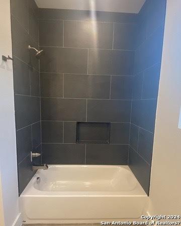 bathroom featuring tiled shower / bath