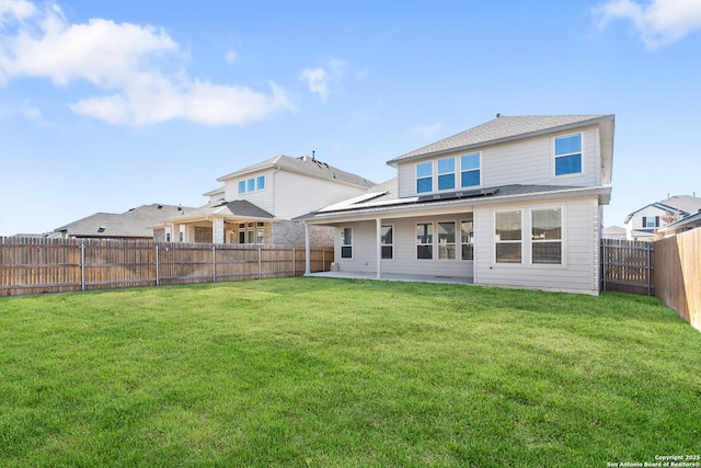 back of house with a yard and a patio