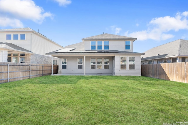 rear view of property featuring a patio area and a lawn