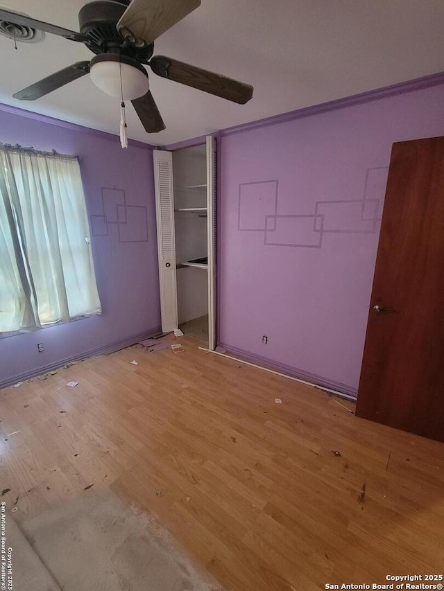 unfurnished bedroom featuring ceiling fan, a closet, and light wood-type flooring