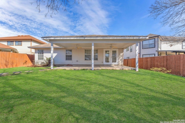 rear view of house with ceiling fan, a yard, and a patio area