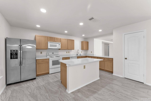 kitchen featuring white appliances, a center island, and sink