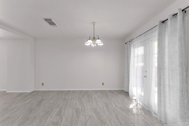 spare room with a notable chandelier