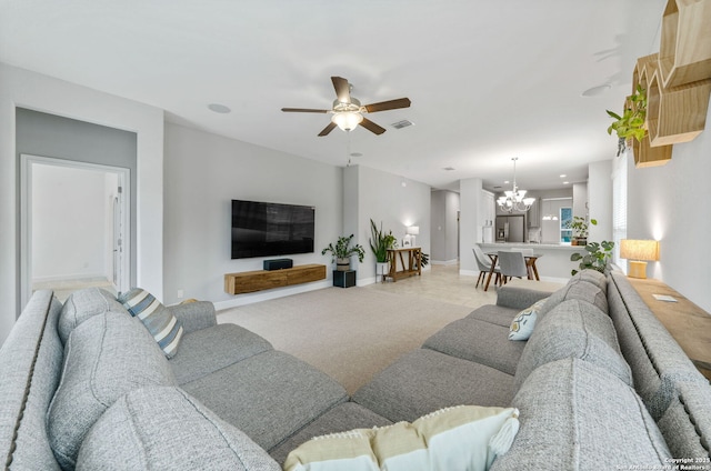 living room with ceiling fan with notable chandelier and light carpet