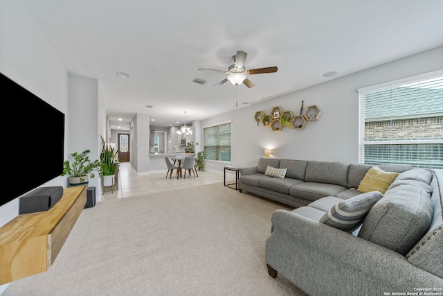 living room featuring ceiling fan with notable chandelier and light tile patterned floors