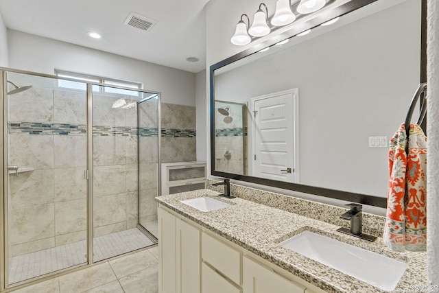 bathroom with walk in shower, vanity, and tile patterned flooring