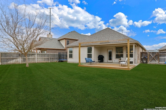 back of house featuring a lawn and a patio area