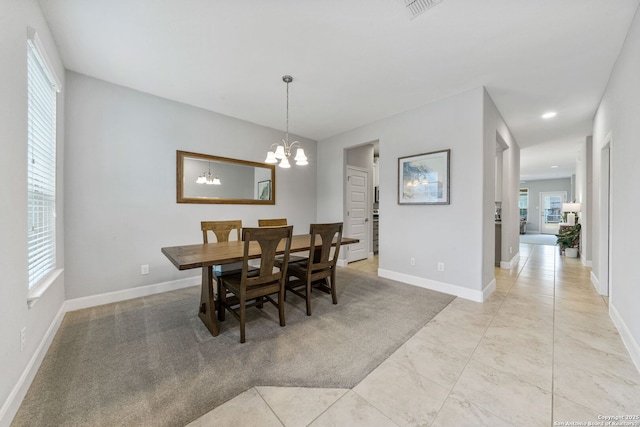 dining space featuring light tile patterned floors and a notable chandelier