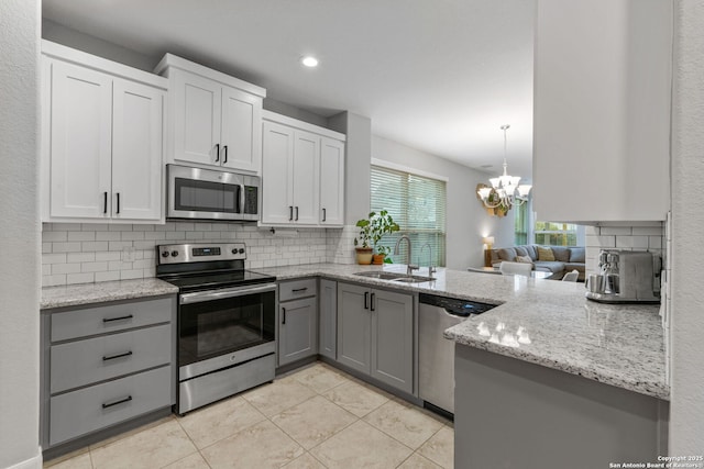 kitchen with sink, decorative backsplash, white cabinets, and appliances with stainless steel finishes