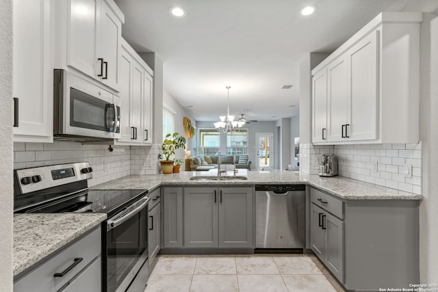 kitchen featuring light tile patterned flooring, sink, gray cabinetry, stainless steel appliances, and backsplash