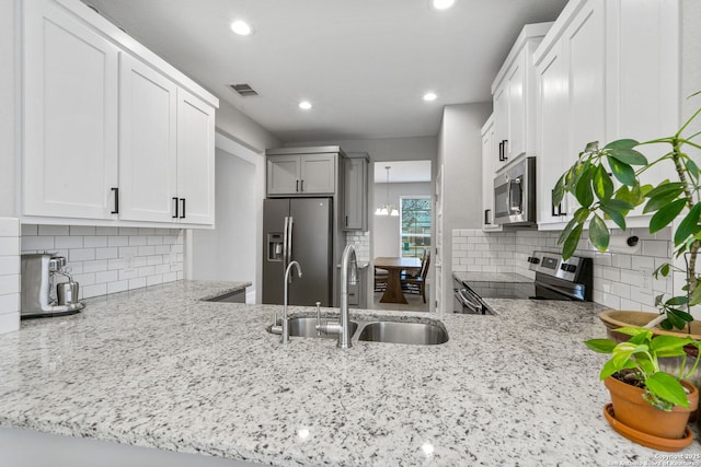 kitchen featuring stainless steel appliances, sink, white cabinets, and backsplash