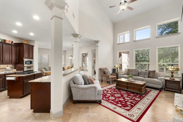 living room featuring decorative columns, recessed lighting, visible vents, ceiling fan, and high vaulted ceiling