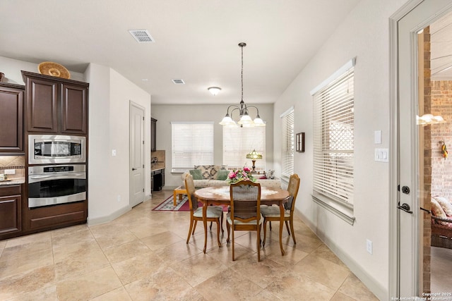 dining space featuring visible vents, a notable chandelier, baseboards, and light tile patterned floors