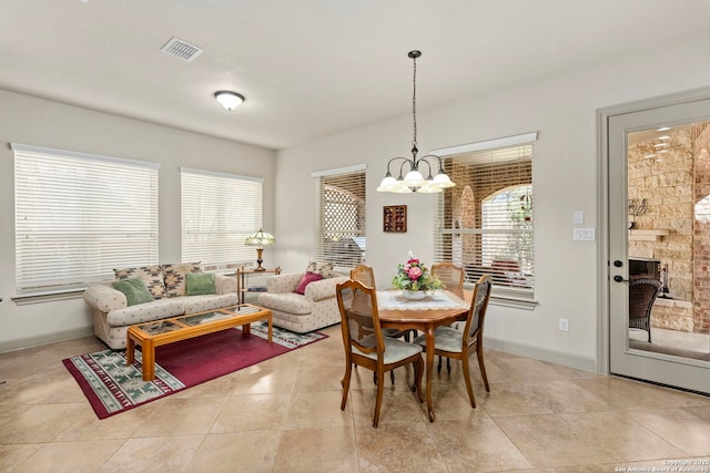 dining room featuring a chandelier, light tile patterned flooring, visible vents, and baseboards