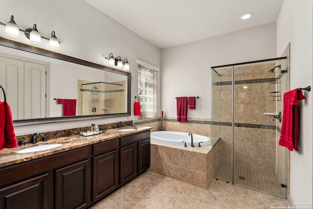 bathroom with a stall shower, double vanity, a sink, and a bath