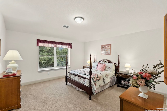 bedroom featuring baseboards, visible vents, and light colored carpet