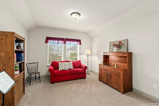 sitting room with vaulted ceiling, baseboards, and light colored carpet