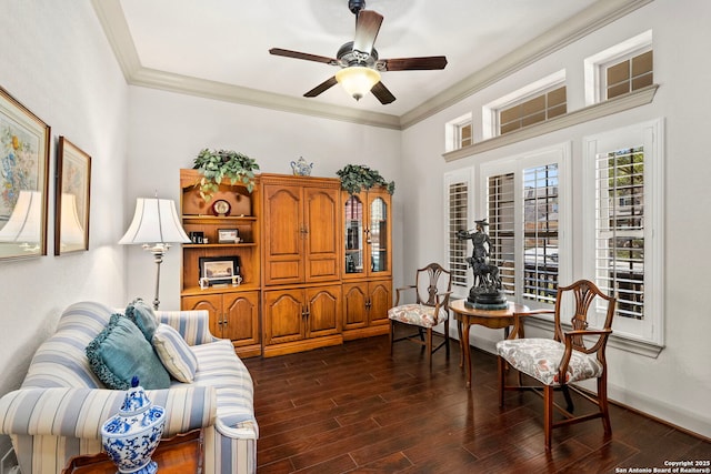 sitting room with ceiling fan, ornamental molding, dark wood-style flooring, and baseboards