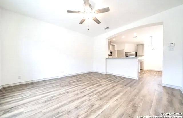 unfurnished living room featuring ceiling fan and light hardwood / wood-style floors