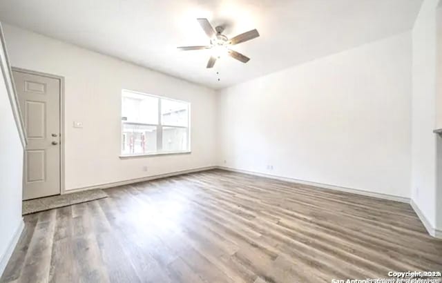 empty room with hardwood / wood-style floors and ceiling fan