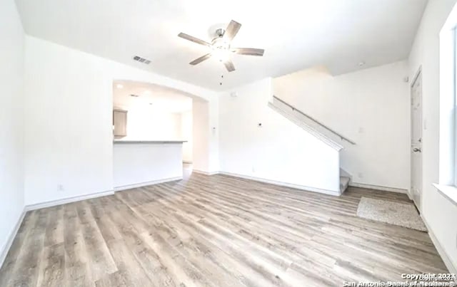 unfurnished living room featuring ceiling fan and light wood-type flooring