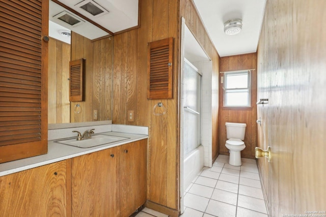 full bathroom featuring tile patterned floors, toilet, vanity, and wood walls