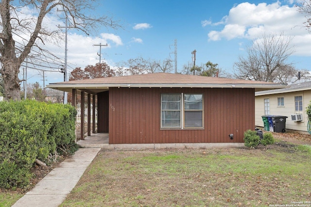 view of side of home with cooling unit and a yard