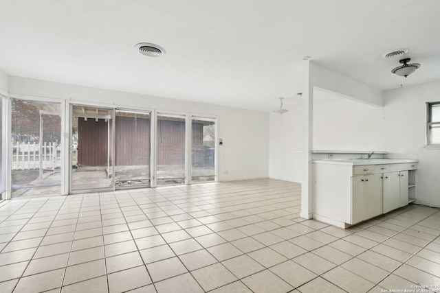 interior space with light tile patterned floors and sink