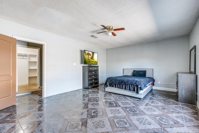 bedroom featuring ceiling fan and a textured ceiling