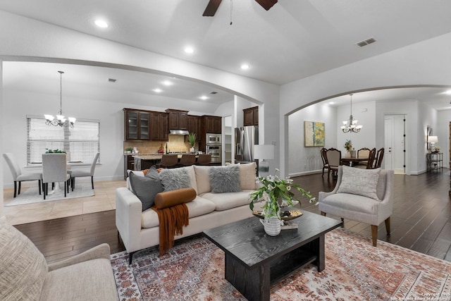 living room featuring hardwood / wood-style flooring and ceiling fan with notable chandelier