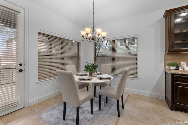 tiled dining area with vaulted ceiling and a chandelier