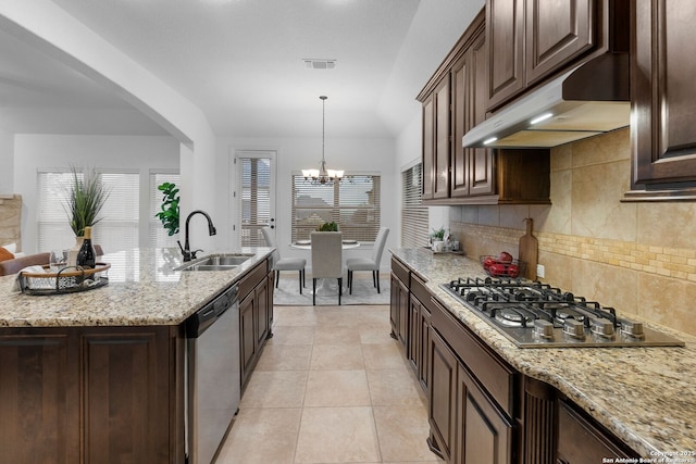 kitchen featuring dark brown cabinetry, sink, light stone counters, and appliances with stainless steel finishes