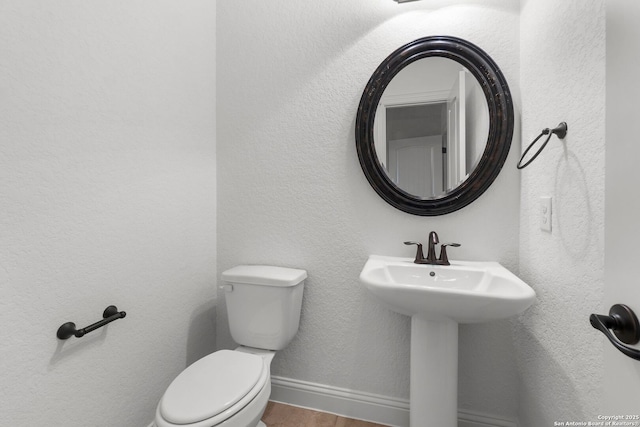 bathroom with hardwood / wood-style flooring, sink, and toilet