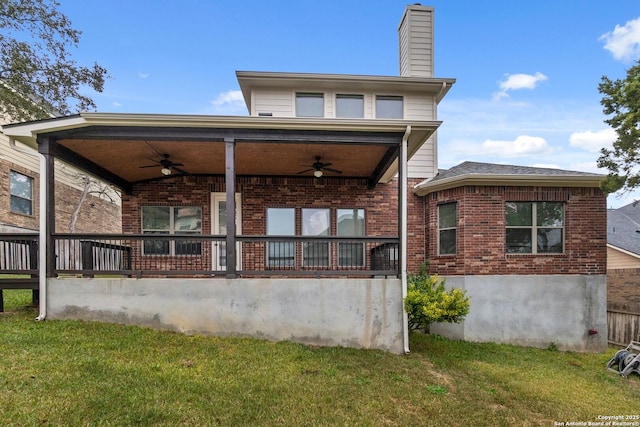 rear view of house with a lawn and ceiling fan