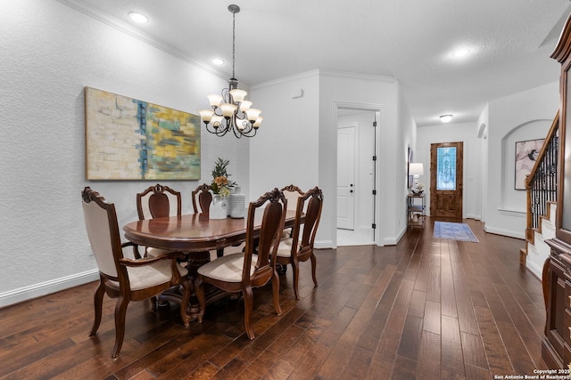 dining area with dark wood-type flooring, ornamental molding, and a notable chandelier