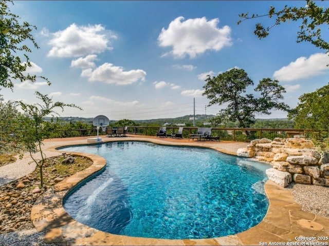 view of swimming pool featuring pool water feature and a patio area