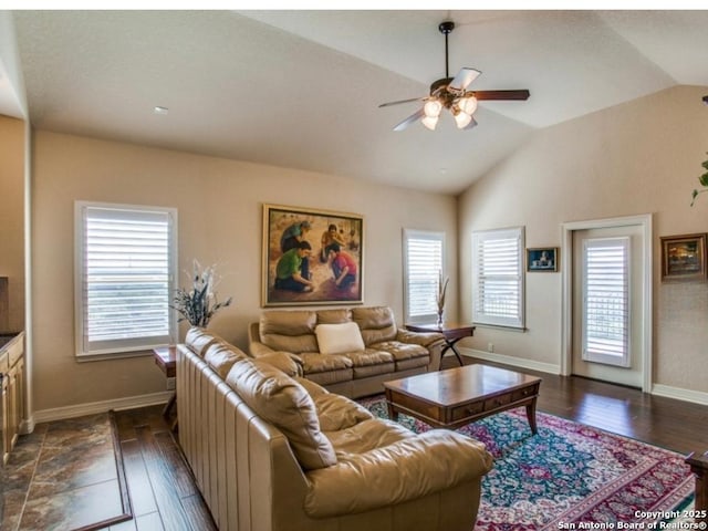 living room featuring dark hardwood / wood-style flooring, vaulted ceiling, and a healthy amount of sunlight