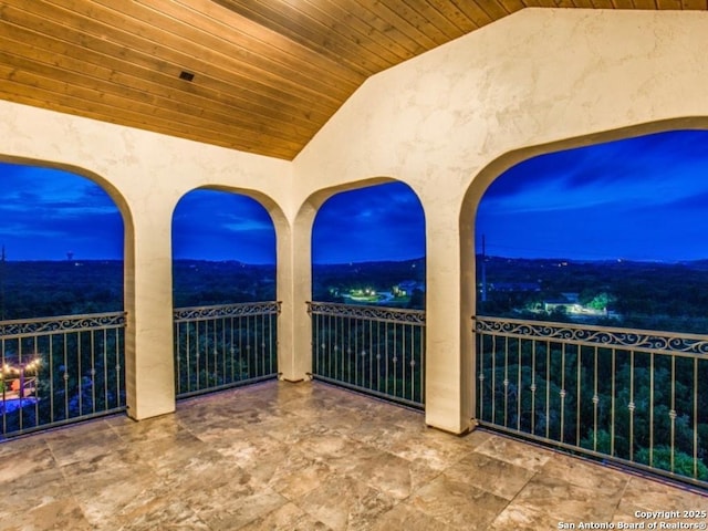 patio terrace at dusk featuring a balcony