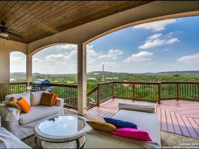 wooden terrace featuring an outdoor living space, grilling area, and ceiling fan