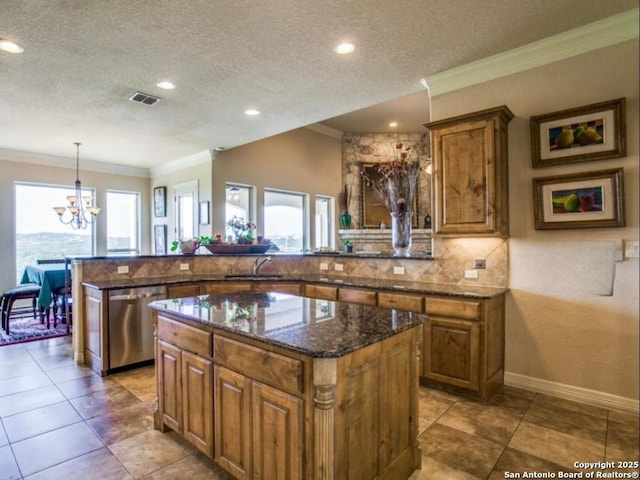 kitchen with decorative light fixtures, stainless steel dishwasher, a center island, and a textured ceiling