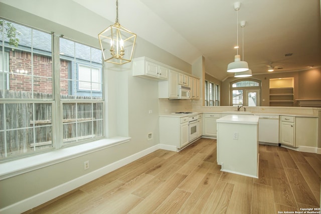 kitchen with pendant lighting, white cabinets, white appliances, and kitchen peninsula