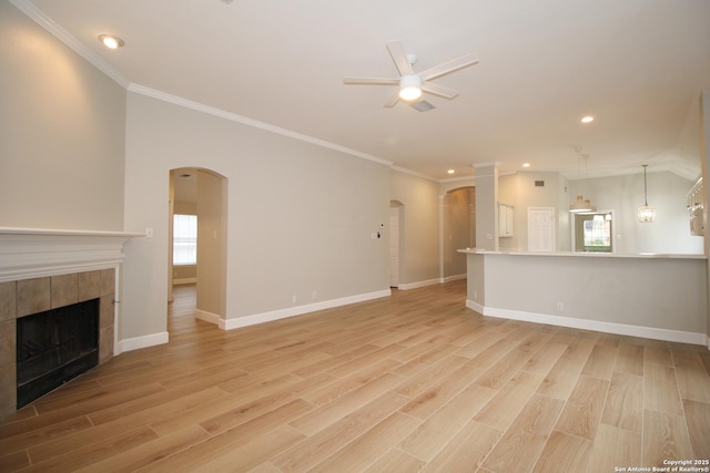 unfurnished living room featuring ceiling fan, crown molding, a fireplace, and light hardwood / wood-style floors