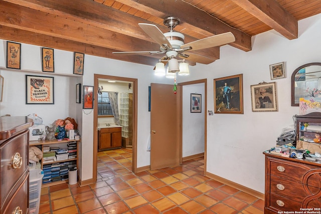 bedroom with light tile patterned floors, beam ceiling, and wooden ceiling